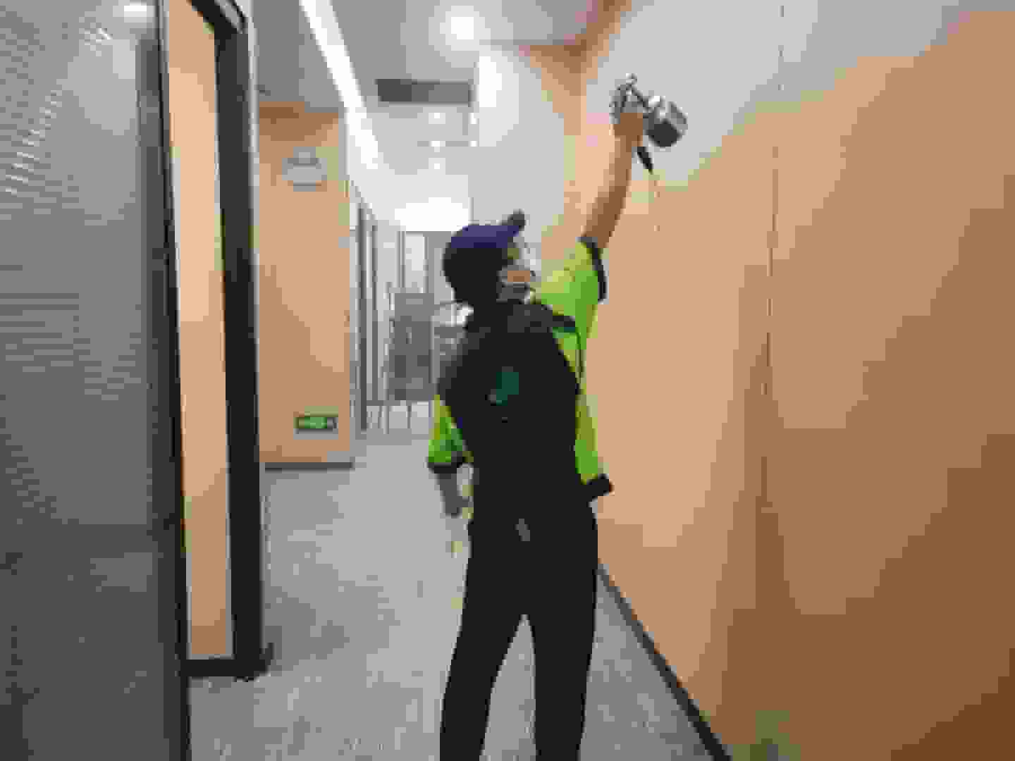 檢測人員在書房，將檢測儀器的采樣管伸到書架旁，設定好檢測時間，準備采集空氣樣本。